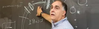 a faculty member draws on a blackboard